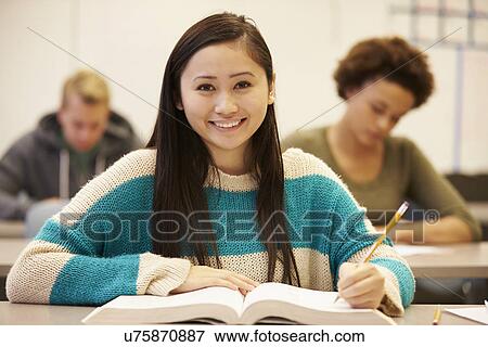 Stock Photo - Female High School Student Studying At Desk In Classroom. Fotosearch
