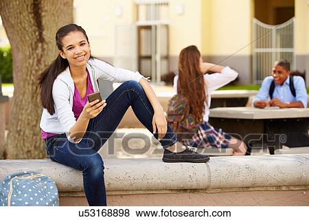 Stock Photo - Female High School Student Using Phone On School Campus . Fotosearch