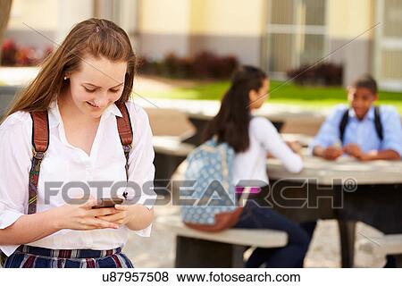 Stock Photo - Female High School Student Using Phone On School Campus . Fotosearch