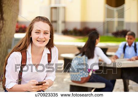 Stock Photography - Female High School Student Using Phone On School Campus . Fotosearch