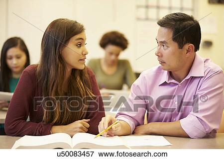 Female High School Student With Teacher Studying At Desk View Large Photo Image Stock Photo - Female High School Student With Teacher Studying At Desk. Fotosearch