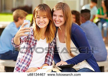 Stock Photo - Female High School Students Taking Selfie On Campus . Fotosearch