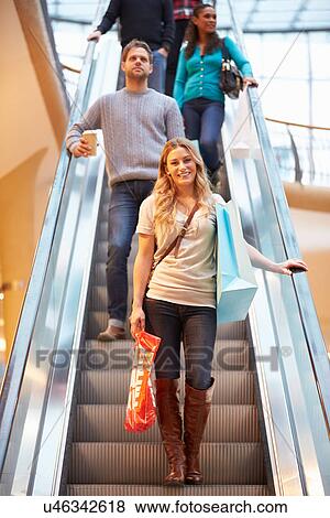 Stock Photo - Female Shopper On Escalator In Shopping Mall. Fotosearch
