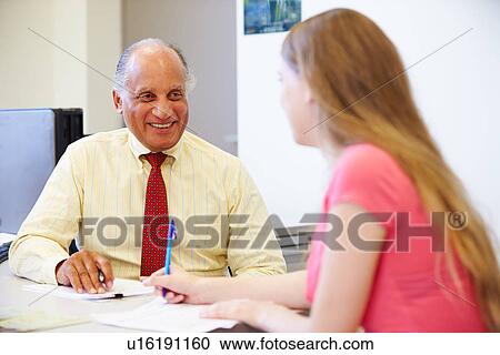 Stock Image - Female Student Talking To High School Counselor. Fotosearch