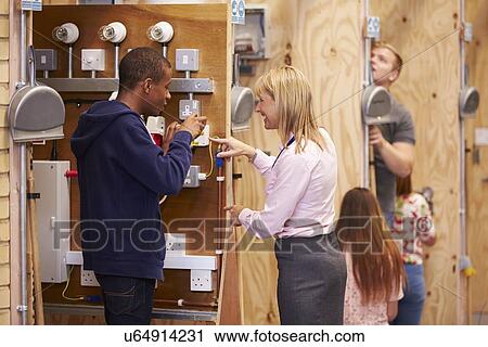 Female Teacher Helping Students Training To Be Electricians View Large Photo Image Stock Image - Female Teacher Helping Students Training To Be Electricians. Fotosearch