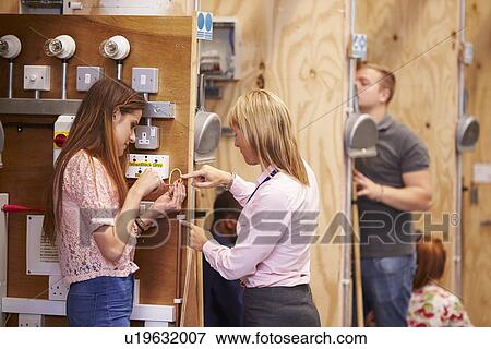 Female Teacher Helping Students Training To Be Electricians View Large Photo Image Stock Photo - Female Teacher Helping Students Training To Be Electricians. Fotosearch