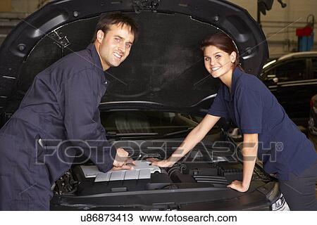 Stock Image - Female trainee mechanic at work. Fotosearch