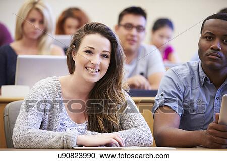 Stock Image - Female University Student Using Digital Tablet In Lecture. Fotosearch