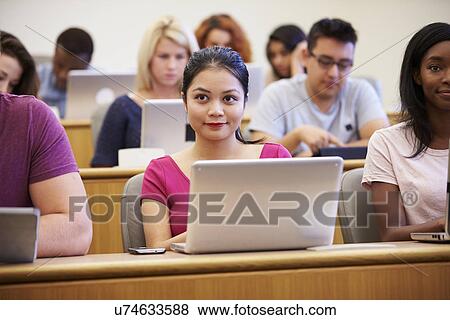 Stock Photo - Female University Student Using Laptop In Lecture. Fotosearch