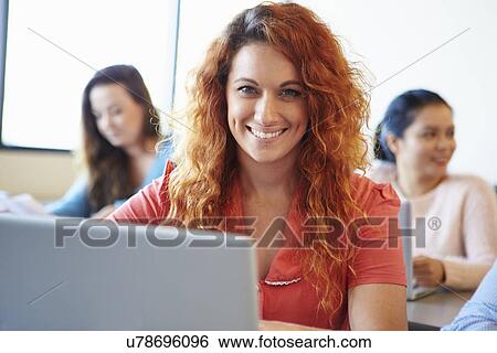 Stock Photograph - Female University Student Using Laptop In Classroom. Fotosearch