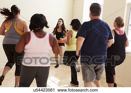 Stock Image - Fitness Instructor In Exercise Class For Overweight People . Fotosearch