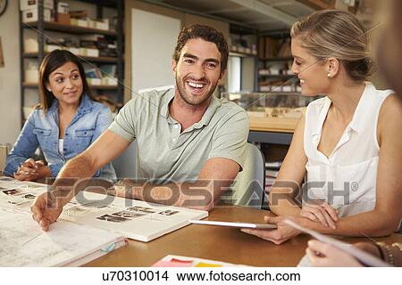 Four Architects Sitting Around Table Having Meeting View Large Photo Image Picture - Four Architects Sitting Around Table Having Meeting. Fotosearch