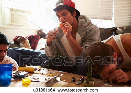Picture - Gang Of Young Men Taking Drugs Indoors . Fotosearch