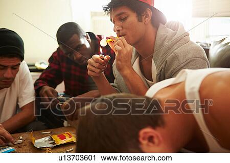 Stock Image - Gang Of Young Men Taking Drugs Indoors . Fotosearch