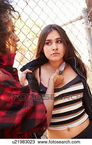 Stock Image - Girl Being Threatened With Knife By Female Gang Member. Fotosearch