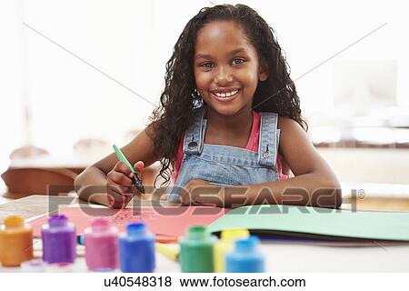 Stock Photo - Girl Painting Picture On Table At Home. Fotosearch