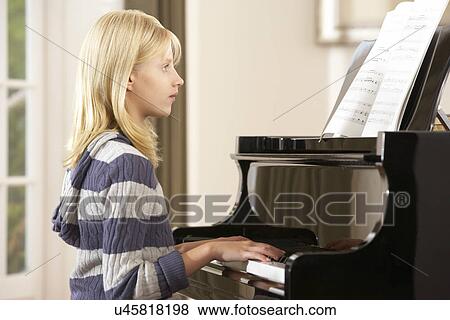 Girl playing grand piano at home View Large Photo Image Stock Photo - Girl playing grand piano at home. Fotosearch