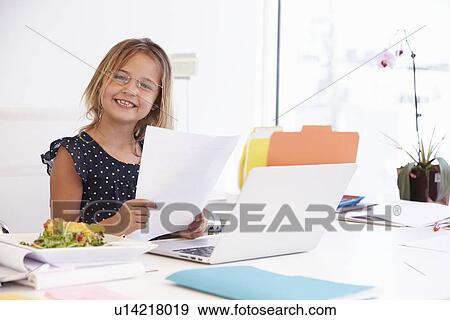 Stock Photo - Girl Pretending To Be Businesswoman Working At Desk. Fotosearch