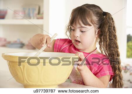 Girl with Downs Syndrome baking View Large Photo Image Stock Photo - Girl with Downs Syndrome baking. Fotosearch