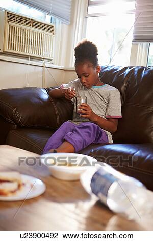 Girl With Poor Diet Eating Meal On Sofa At Home View Large Photo Image Stock Image - Girl With Poor Diet Eating Meal On Sofa At Home. Fotosearch