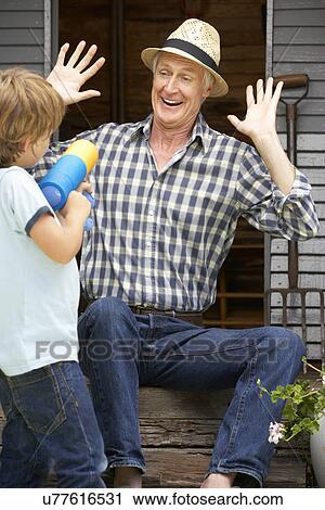 Grandfather and grandson playing in garden View Large Photo Image Stock Image - Grandfather and grandson playing in garden. Fotosearch