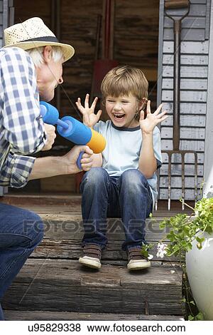 Stock Photo - Grandfather and grandson playing in garden. Fotosearch