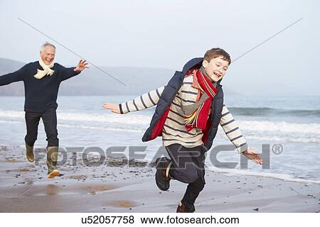 Stock Photo - Grandfather And Grandson Running On Winter Beach. Fotosearch