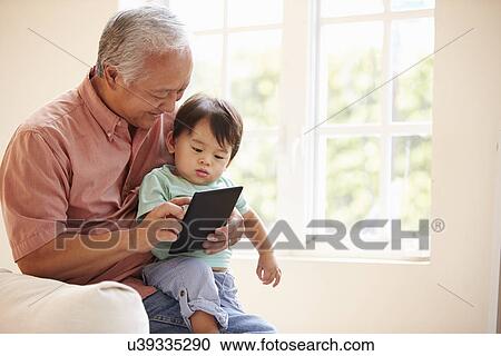 Grandfather And Grandson Using Digital Tablet Together View Large Photo Image Stock Image - Grandfather And Grandson Using Digital Tablet Together. Fotosearch