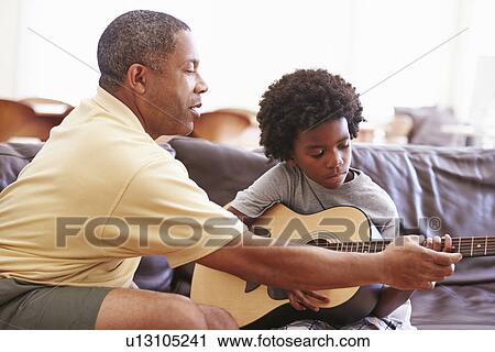 Grandfather Teaching Grandson To Play Guitar View Large Photo Image Stock Image - Grandfather Teaching Grandson To Play Guitar. Fotosearch