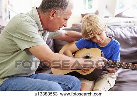 Grandfather Teaching Grandson To Play Guitar View Large Photo Image Stock Image - Grandfather Teaching Grandson To Play Guitar. Fotosearch