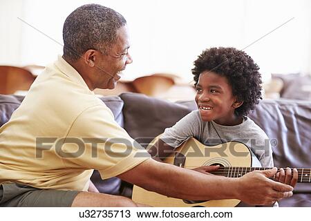 Grandfather Teaching Grandson To Play Guitar View Large Photo Image Stock Image - Grandfather Teaching Grandson To Play Guitar. Fotosearch