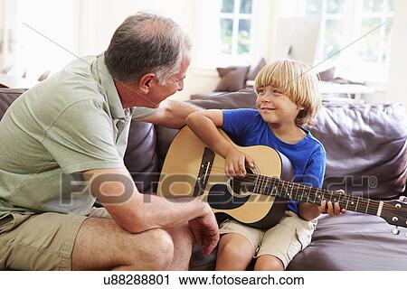 Grandfather Teaching Grandson To Play Guitar View Large Photo Image Stock Image - Grandfather Teaching Grandson To Play Guitar. Fotosearch