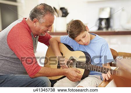 Grandfather Teaching Grandson To Play Guitar View Large Photo Image Stock Photo - Grandfather Teaching Grandson To Play Guitar. Fotosearch