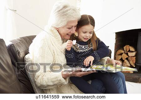 Grandmother And Granddaughter Reading Book At Home Together View Large Photo Image Stock Photo - Grandmother And Granddaughter Reading Book At Home Together. Fotosearch