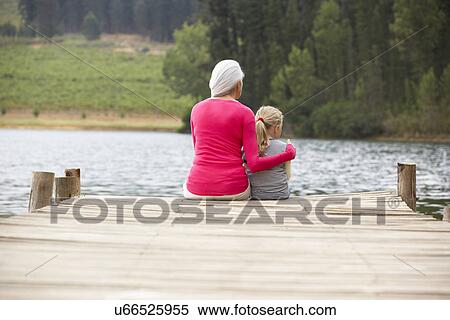 Grandmother and granddaughter sitting on a jetty View Large Photo Image Stock Photography - Grandmother and granddaughter sitting on a jetty. Fotosearch