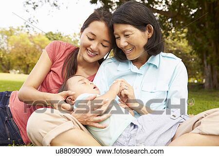 Stock Image - Grandmother In Park With Grandson And Daughter. Fotosearch