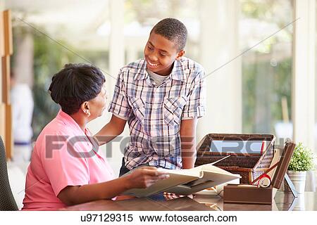 Grandmother Looking At Photo Album With Grandson View Large Photo Image Stock Photography - Grandmother Looking At Photo Album With Grandson. Fotosearch