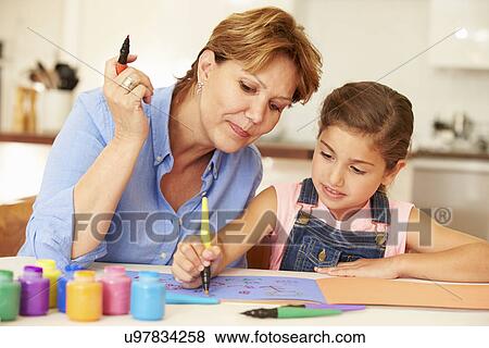 Stock Photo - Grandmother Painting With Granddaughter At Home. Fotosearch