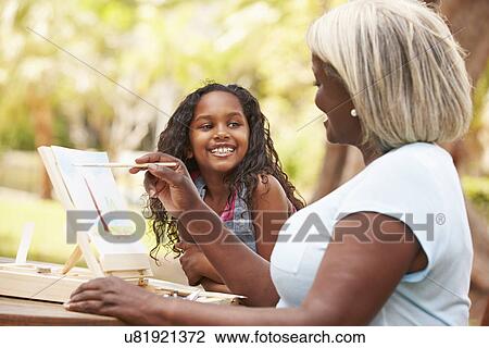 Stock Image - Grandmother With Granddaughter Outdoors Painting Landscape. Fotosearch