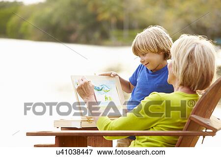 Stock Photo - Grandmother With Grandson Outdoors Painting Landscape. Fotosearch