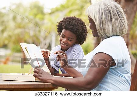Stock Photograph - Grandmother With Grandson Outdoors Painting Landscape. Fotosearch