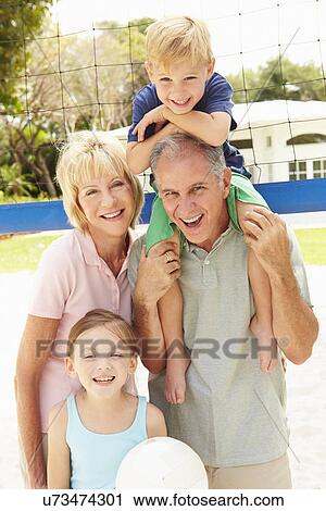 Stock Image - Grandparents And Grandchildren Playing Volleyball Together. Fotosearch