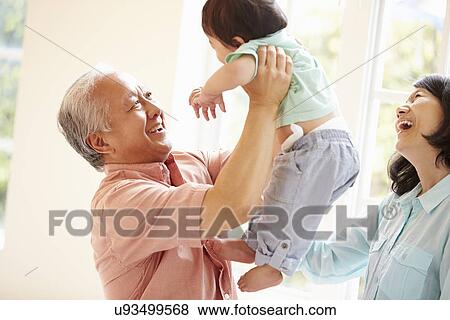 Stock Photo - Grandparents And Grandson Playing Game Indoors Together. Fotosearch