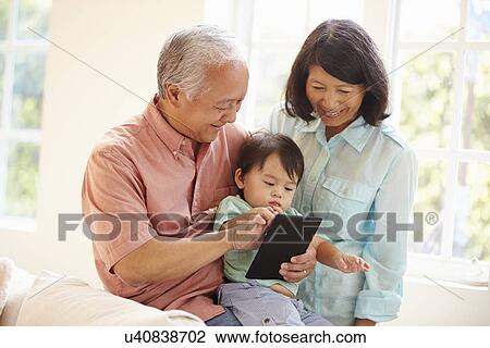 Grandparents And Grandson Using Digital Tablet Together View Large Photo Image Stock Image - Grandparents And Grandson Using Digital Tablet Together. Fotosearch