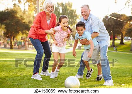 Stock Photo - Grandparents Playing Soccer With Grandchildren In Park. Fotosearch