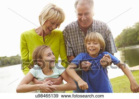 Stock Photo - Grandparents Playing With Grandchildren Outdoors. Fotosearch