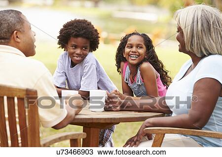 Grandparents Relaxing Whilst Grandchildren Play In Garden View Large Photo Image Stock Image - Grandparents Relaxing Whilst Grandchildren Play In Garden . Fotosearch