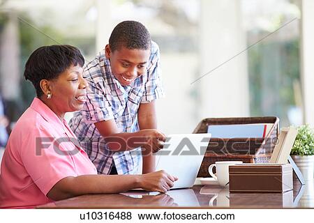 Stock Photo - Grandson Helping Grandmother With Laptop. Fotosearch
