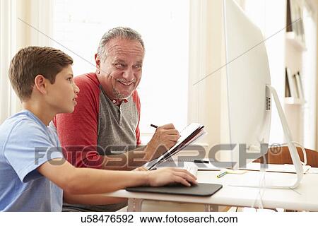 Stock Image - Grandson Teaching Grandfather To Use Computer. Fotosearch