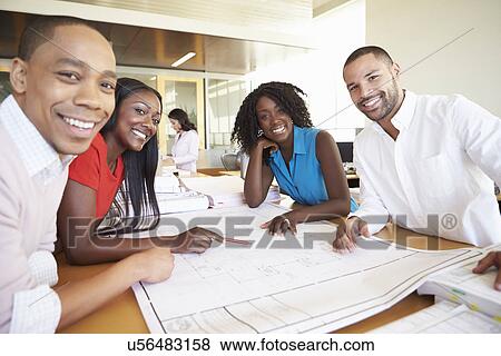 Group Of Architects Discussing Plans In Modern Office View Large Photo Image Stock Photo - Group Of Architects Discussing Plans In Modern Office. Fotosearch